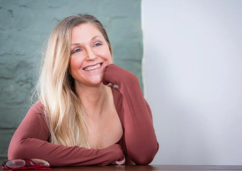 A photo of Elly Hamilton, the confidence and life coach sat at a desk